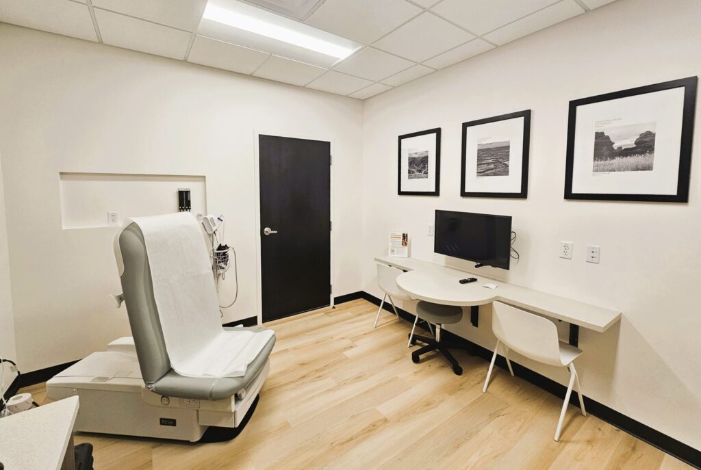 Exam room with built-in consult desk at Crossover Health in Layton, Utah, a medical office build-out by PJF Corporation