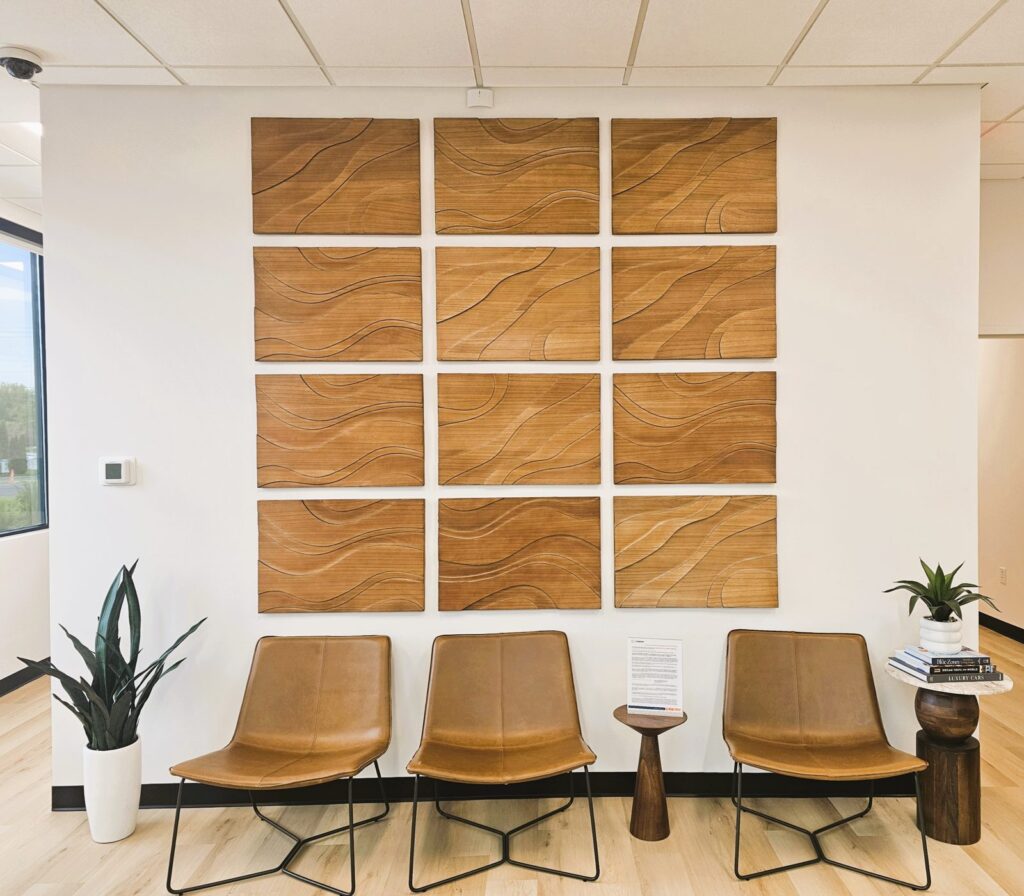 Patient waiting area with carved wood feature wall at Crossover Health in Layton, Utah, a medical office tenant improvement by PJF Corporation