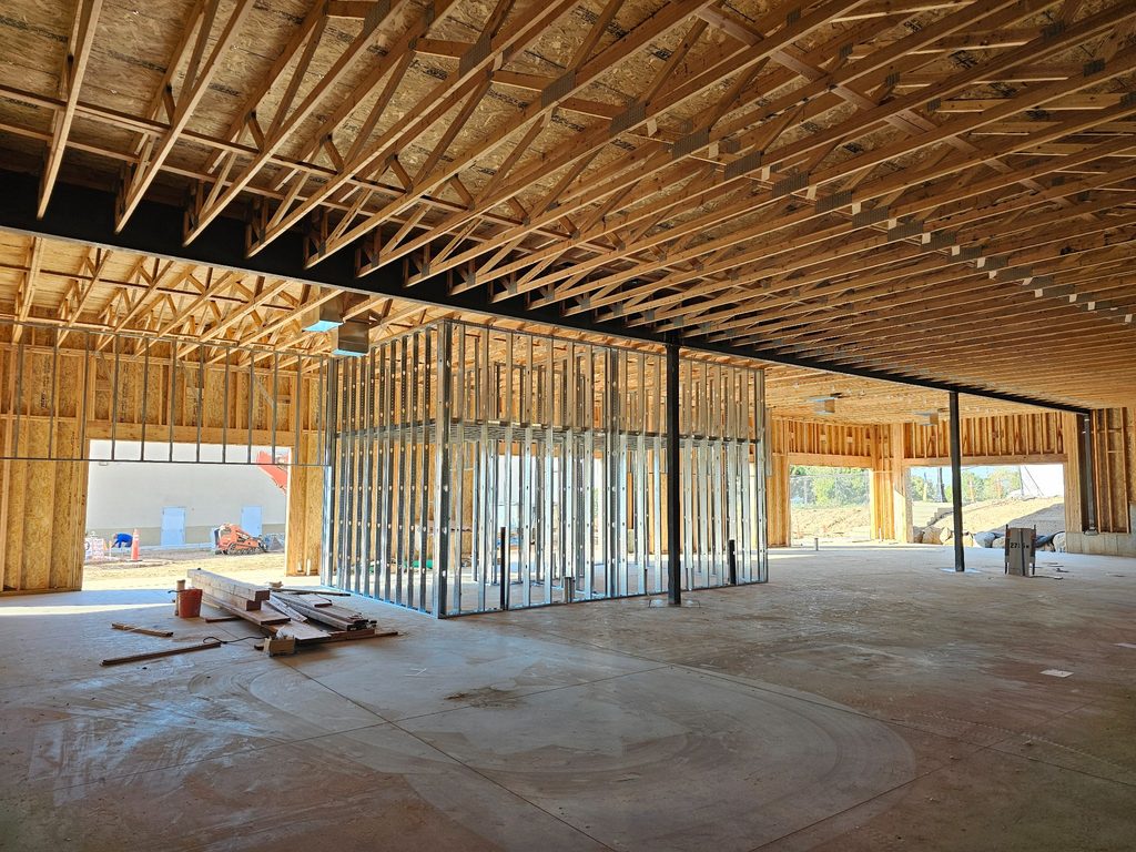 Interior framing with metal studs, structural steel, and wood roof trusses in a Layton, Utah commercial office building under construction