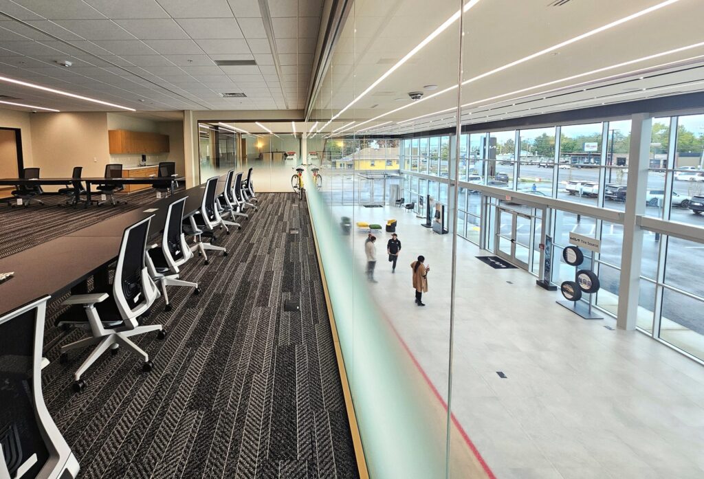 Mezzanine conference room with a glass railing overlooking the Young Kia showroom floor in Layton, Utah