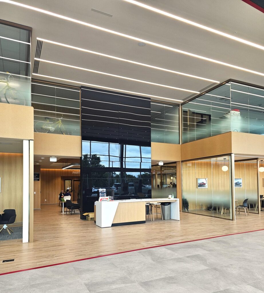 Reception desk and two-story black feature wall in the Young Kia Layton showroom