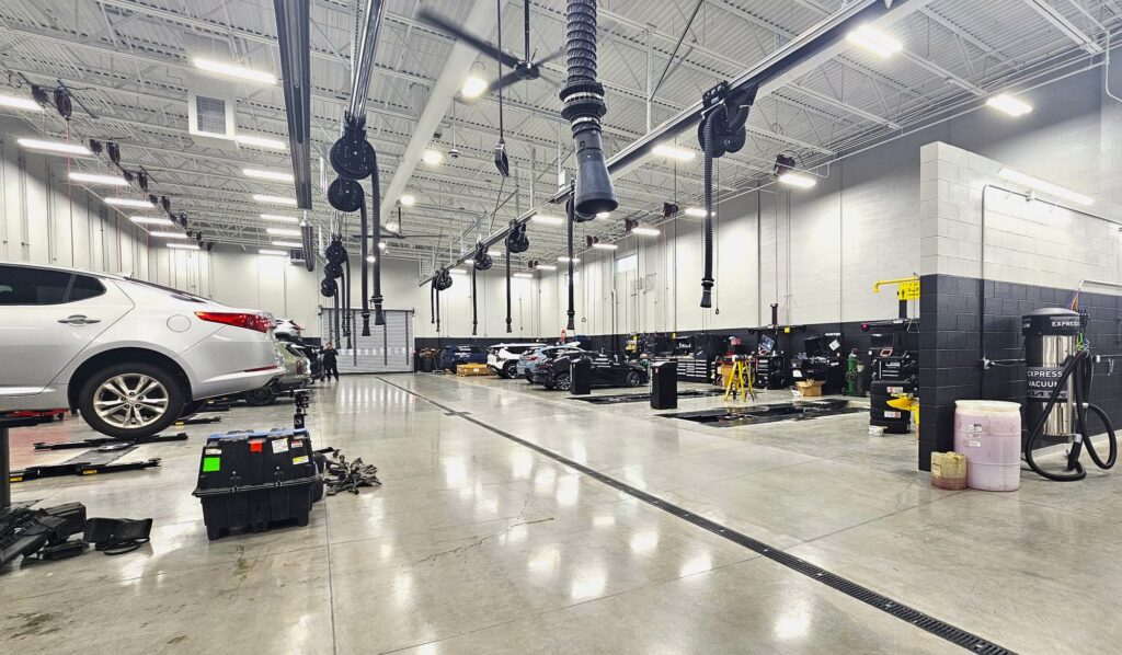 Young Kia Layton service shop built by CM/GC PJF Corporation, with polished concrete floors, overhead exhaust reels, trench drain and alignment bays